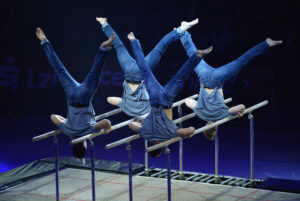 Die vierköpfige Turnergruppe mit Aktobatik am Trampolin und Parallelbarren